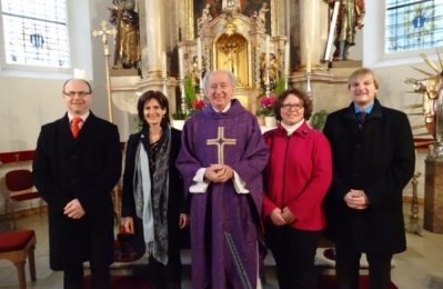 Fünf Personen lächeln, in der Kirche, in die Kamera