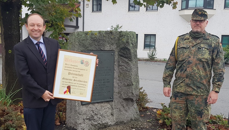 Bürgermeister mit Urkunde in der Hand - rechts Oberstabsfeldwebel Jörg Luther