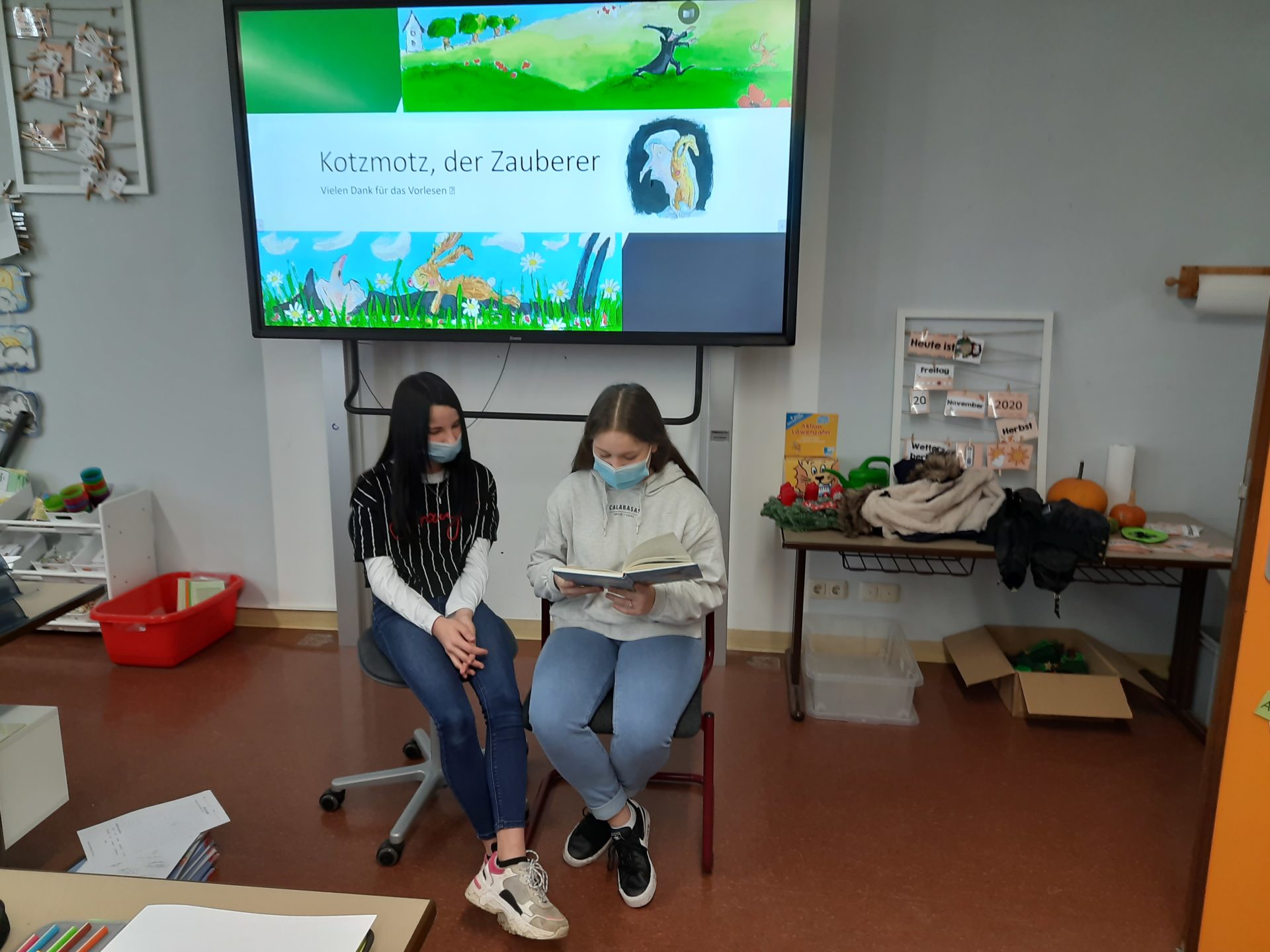 zwei Schülerinnen lesen ein Buch vor