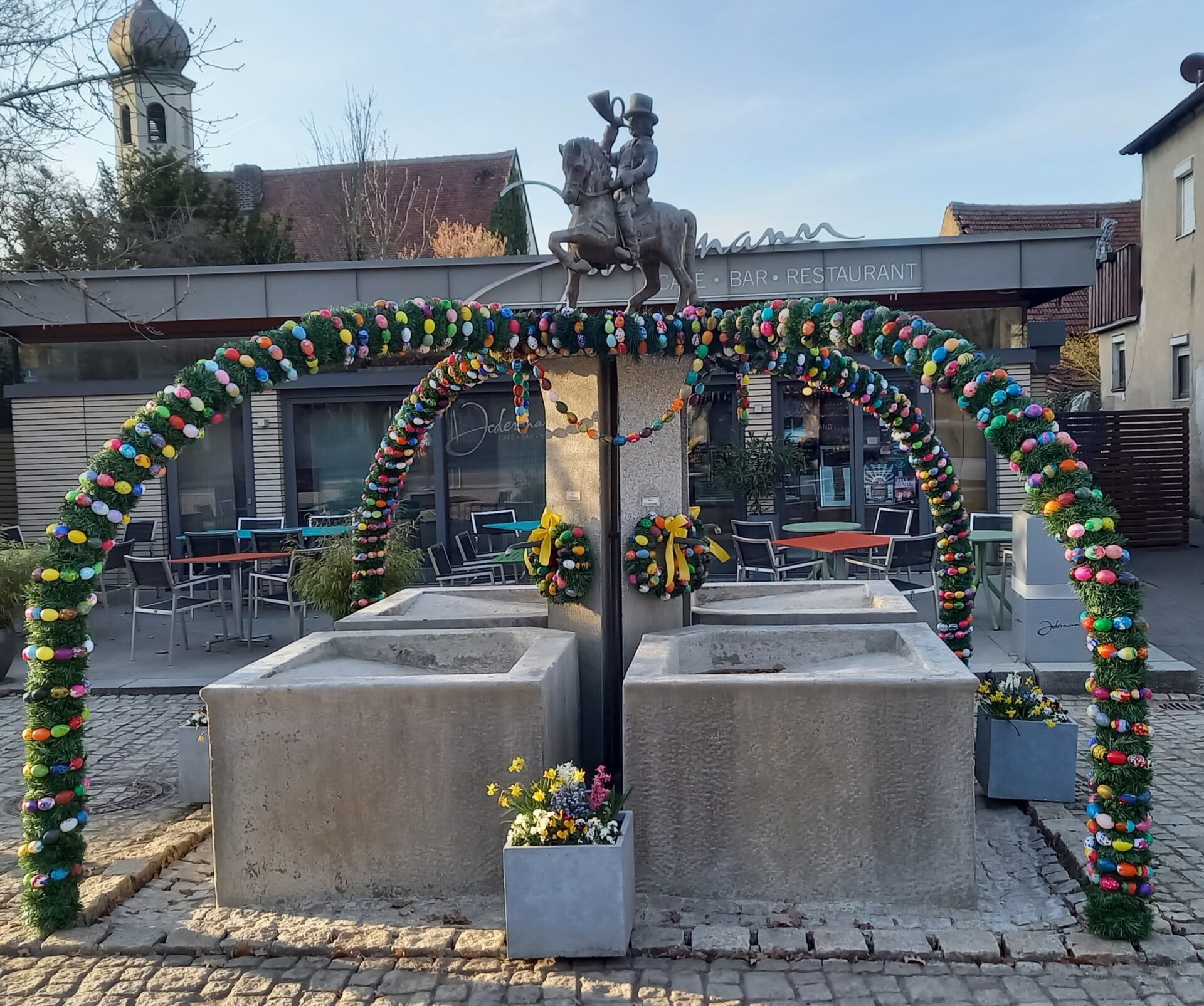 Der Osterbrunnen wird von den ersten Frühlingssonnenstrahlen angestrahlt