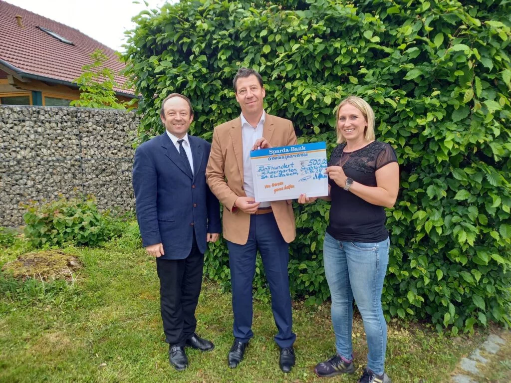 3 Personen bei Scheckübergabe