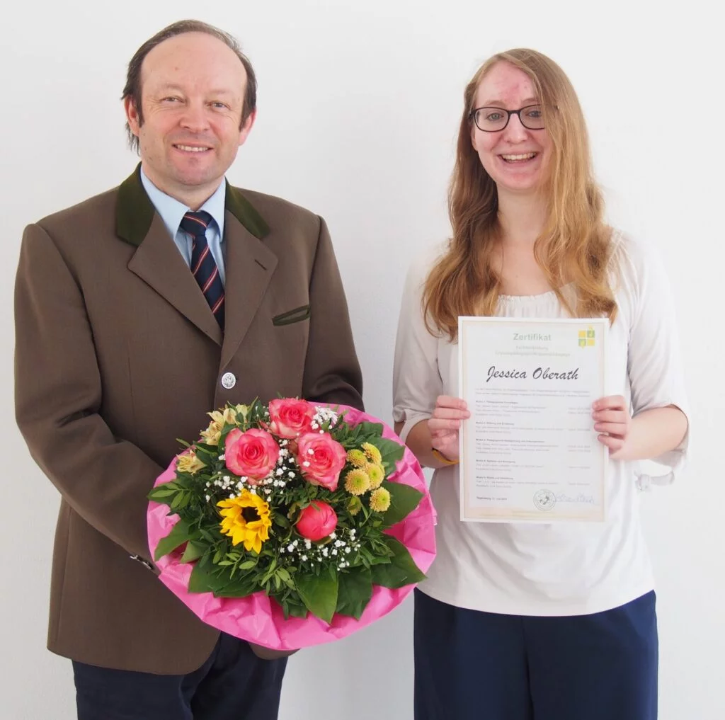 2 Personen bei Zeugnisübergabe