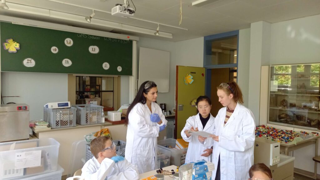 Betreuerinnen erklären Kindern etwas