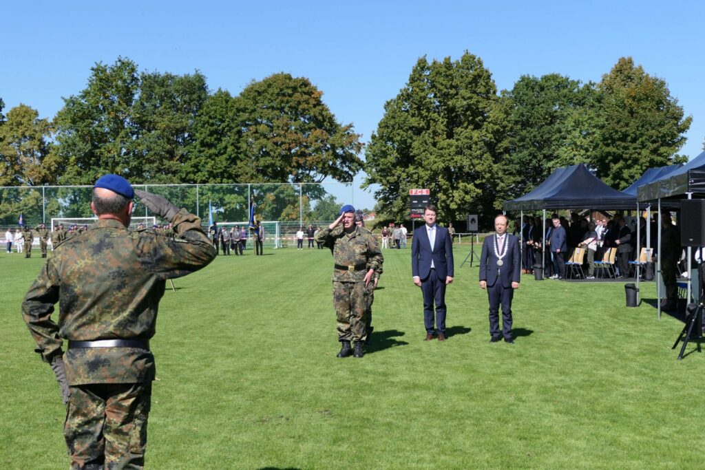 Generalarzt Dr. Bruno Most, Bürgermeister Christian Hirtreiter, Oberstarzt Melanie Heyde und Staatssekretär Sandro bei der Entgegennahme der Meldung durch den Führer der Gelöbnisaufstellung, Oberstleutnant Andreas Urbacezk (mit dem Rücken), auf dem Straßkirchner Sportplatz