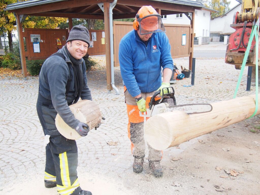 2 Personen beim Zersägen der Maibaumes