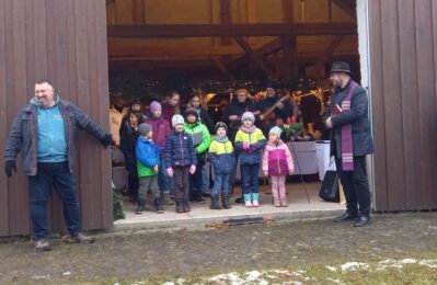 Das traditionelle Ambiente des „Schambach Kids Fördervereins“ beim Adventmarkt ist nach der Eröffnung bis auf den letzten Platz im alten Pfarrstadel mit interessierten Kindern und Besuchern gefüllt. Die besondere Atmosphäre ist auch das Begleitprogramm des Schambacher Adventsmarktes, welches für die Kinder immer ein besonderer Renner ist. Pfarrer Gerhard Pöpperl (re.) freute sich zusammen mit dem Jugendvereinsvorsitzenden Thomas Höcherl (li.) bei der Segnung der Kränze über die gute Beteiligung, sowie die schönen Lieder des vereinseigenen Jugendchores.
