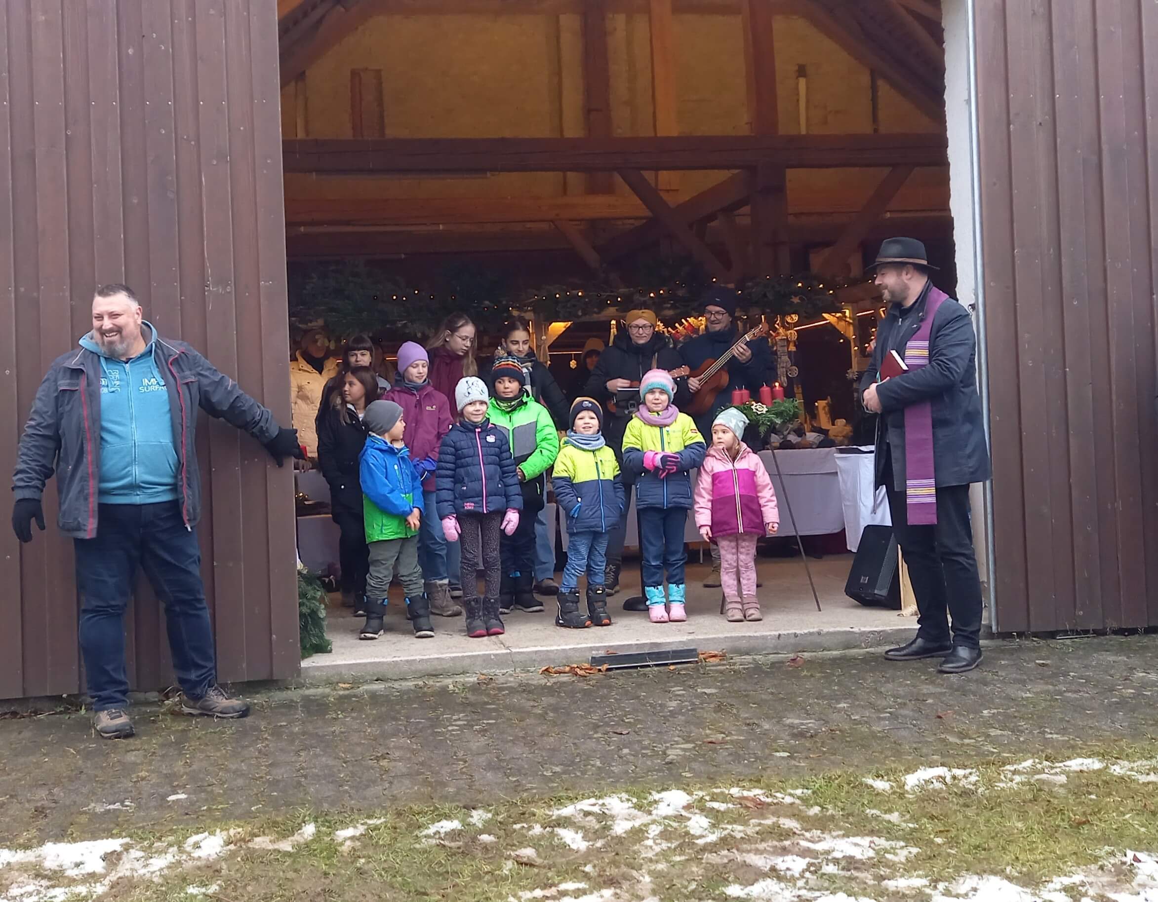Das traditionelle Ambiente des „Schambach Kids Fördervereins“ beim Adventmarkt ist nach der Eröffnung bis auf den letzten Platz im alten Pfarrstadel mit interessierten Kindern und Besuchern gefüllt. Die besondere Atmosphäre ist auch das Begleitprogramm des Schambacher Adventsmarktes, welches für die Kinder immer ein besonderer Renner ist. Pfarrer Gerhard Pöpperl (re.) freute sich zusammen mit dem Jugendvereinsvorsitzenden Thomas Höcherl (li.) bei der Segnung der Kränze über die gute Beteiligung, sowie die schönen Lieder des vereinseigenen Jugendchores.