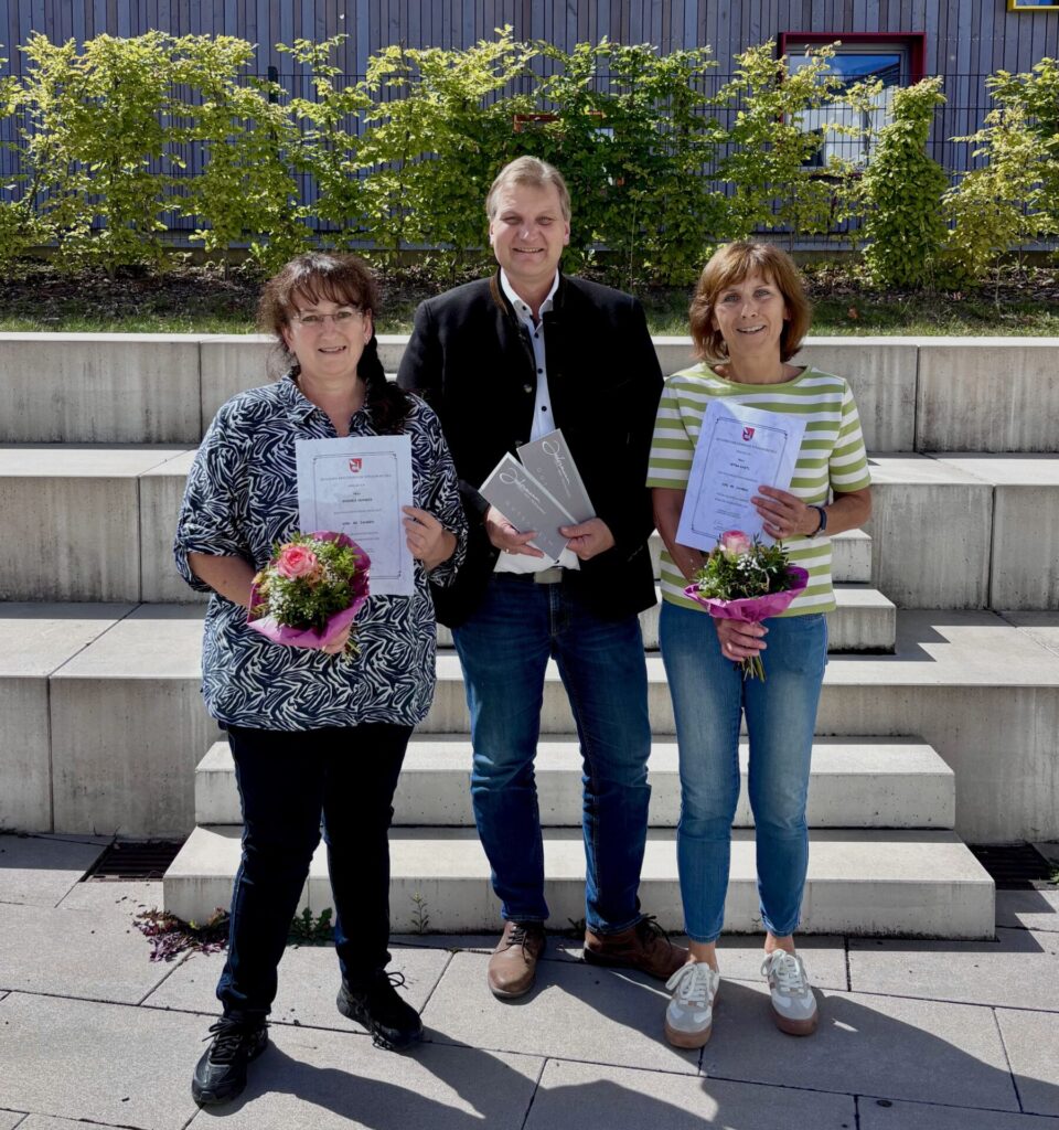 3 Personen bei Urkundenübergabe